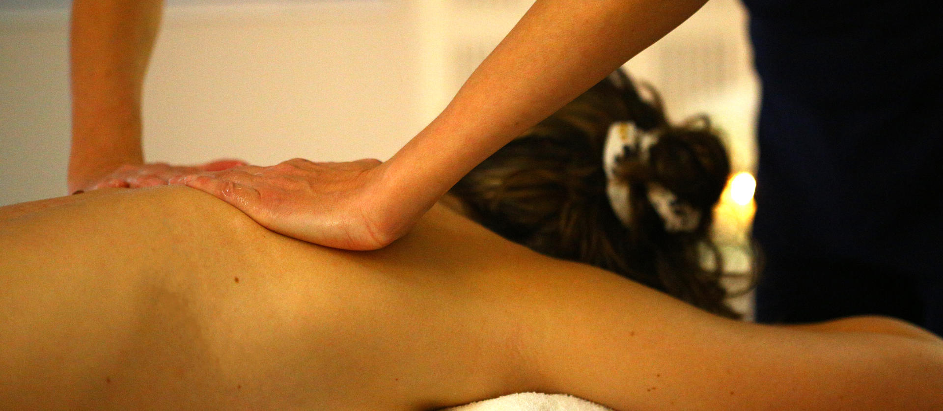 femme se faisant masser le dos par une esthéticienne